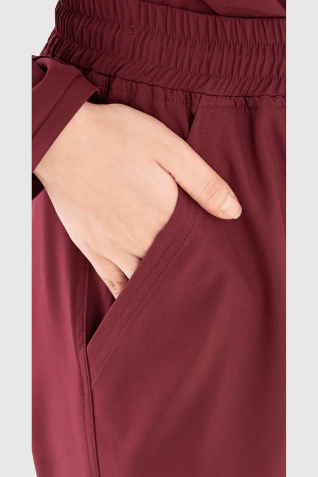Bordo renkli kadın medikal kargo pantolon, elastik bel ve cep detayı yakın çekim.