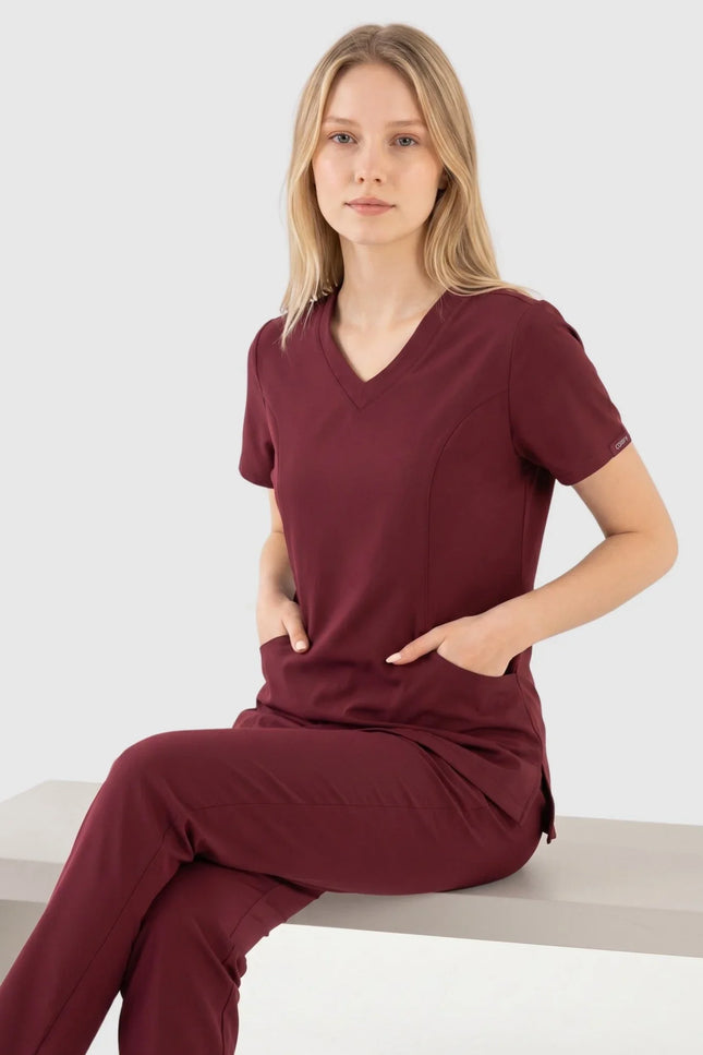 Bordo renkli kadın medikal forma takımı giyen model, damla yaka ve kısa kollu tasarım.